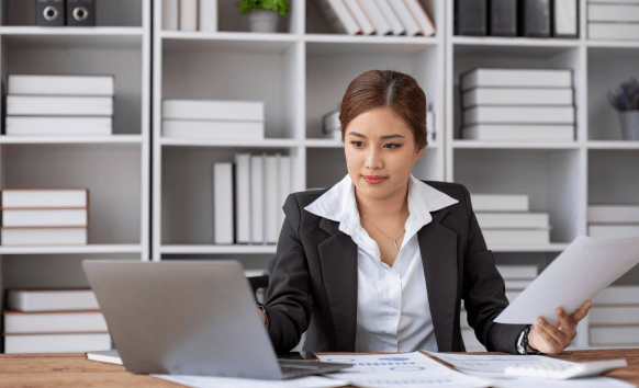 Certified linguists provide Translation Services in Queens, reviewing a stamped document for accuracy at a desk.