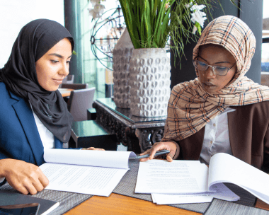 A translator cross-checks Arabic and English chapters as Arabic Translation Services in New York City certify a dissertation.