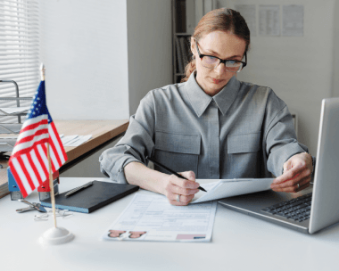 A translator checks a USCIS document checklist beside forms, highlighting Translation Services in Queens for USCIS approval.